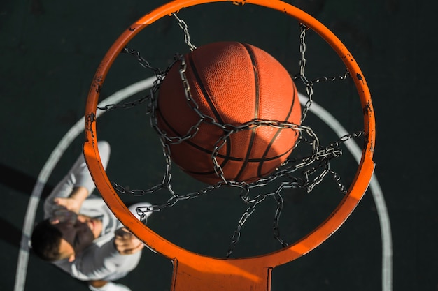 Free photo basketball falling through ring close up