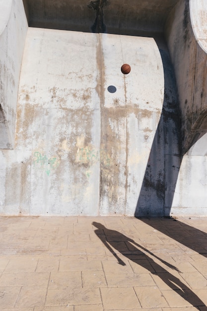 Pallacanestro che colpisce il vecchio muro di cemento