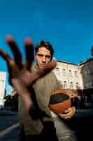 Free photo basketball player covering camera with hand