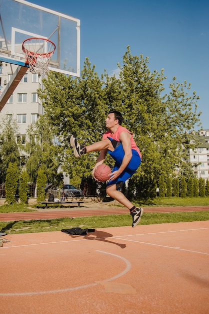 Basketball player doing trick in front of backboard