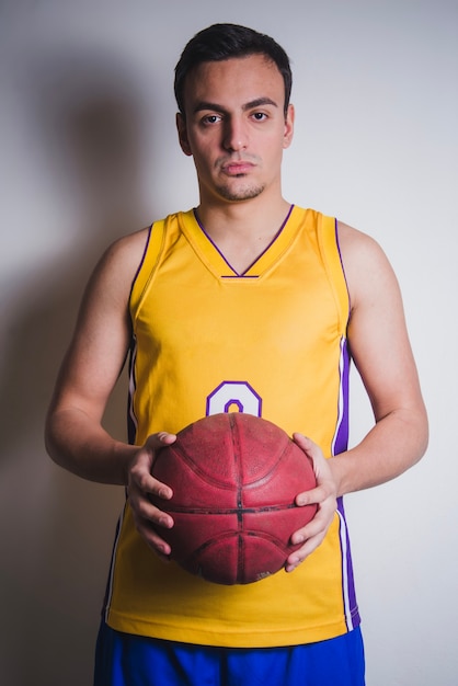 Free photo basketball player posing with ball in hands