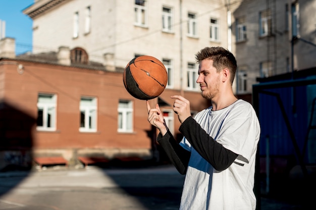 Sfera di filatura del giocatore di pallacanestro sul suo dito