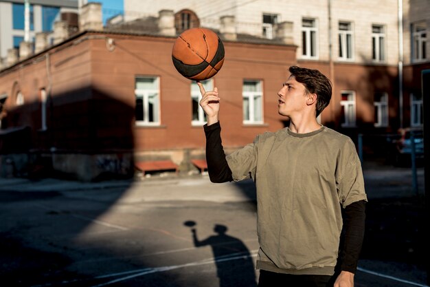 バスケットボール選手が彼の指にボールを回転