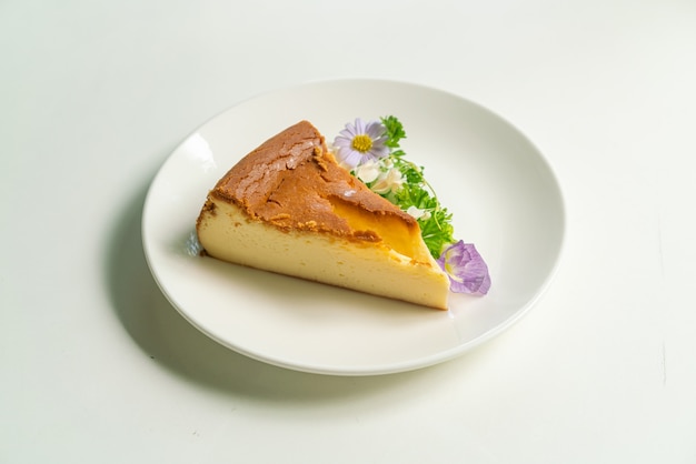 白い​プレート​に​花​と​バスク​焦げた​チーズケーキデコラトイン