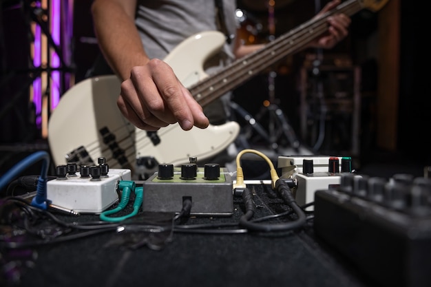 Bassista su un palco con set di pedali per effetti di distorsione.