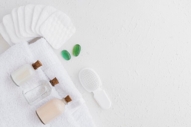 Bath products on towel with cotton pads and copy space