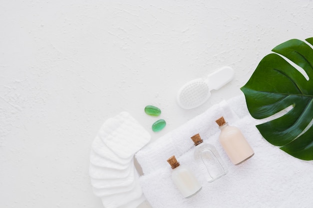 Bath products on towel with cotton pads leaf and copy space