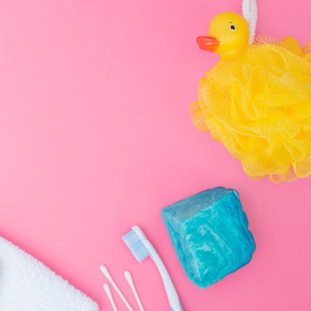 Free photo bath sponge; soap; cotton swab and towel on pink backdrop