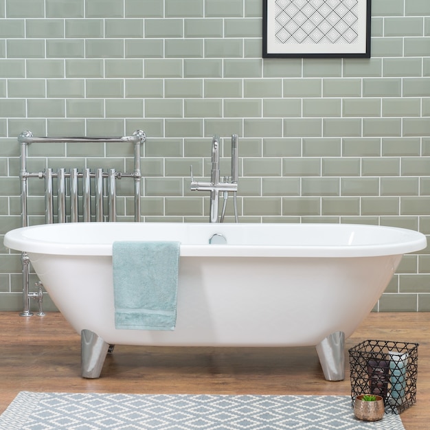 Vasca da bagno in un bagno con pavimento in laminato e parete piastrellata in ceramica, un appartamento in stile loft