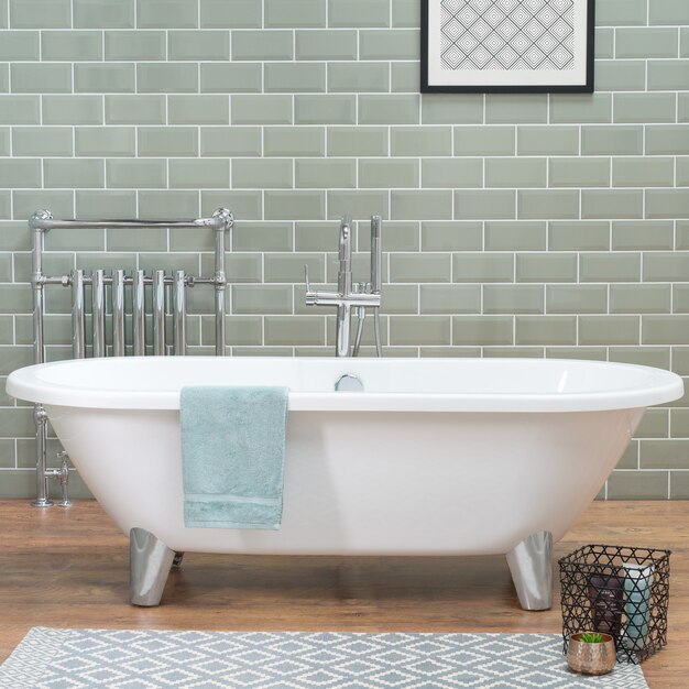 Bathtub in a bathroom with laminate flooring and ceramic tiled wall, a loft style apartment