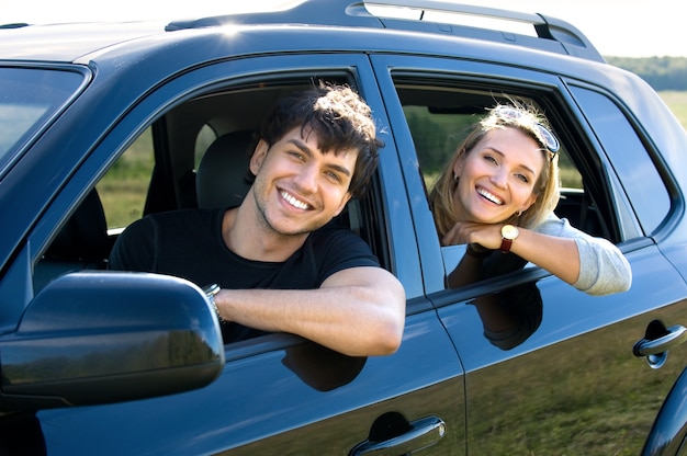 車を運転する美しい幸せな若いカップル