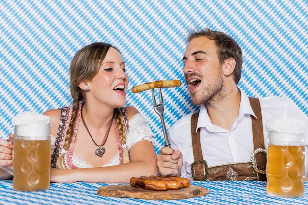 Bavarian couple tasting delicious bratwurst