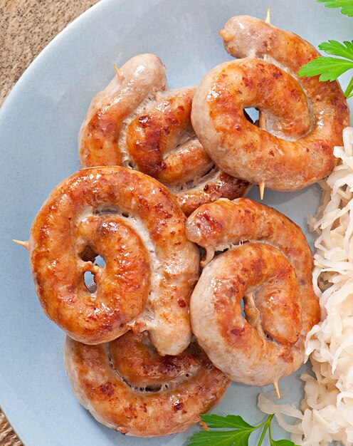 Free photo bavarian fried sausages on sauerkraut