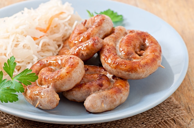 Free photo bavarian fried sausages on sauerkraut