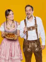 Бесплатное фото Баварский мужчина и женщина, пытаясь bratwurst