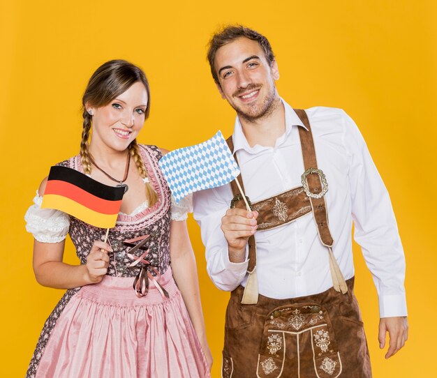 Bavarian man and woman holding flags