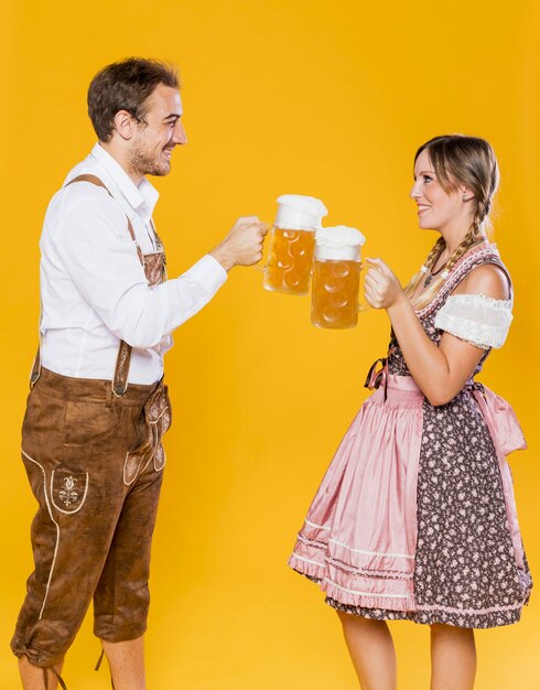 Bavarian young couple toasting beers