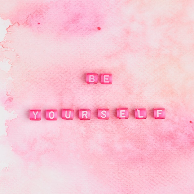 Free photo be yourself beads text typography on pink