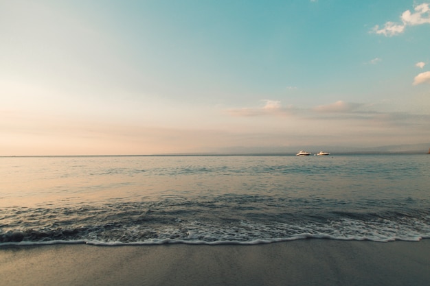 Beach and calm ocean in sunset lights 