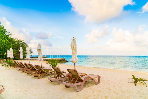 Beach chairs with umbrella at Maldives island, white sandy beach and sea