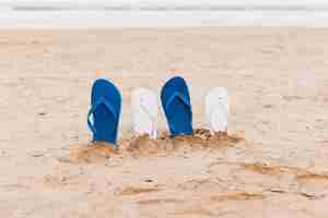 Free photo beach concept with flip flops in sand