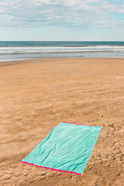 Концепция пляжа с зеленым полотенцем