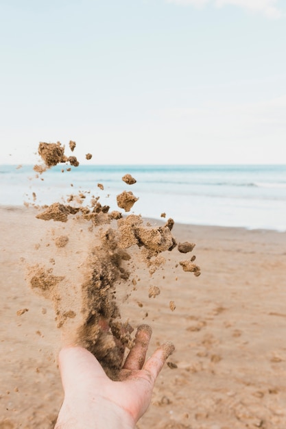 모래를 던지는 손으로 해변 개념