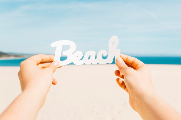 Foto gratuita concetto della spiaggia con le mani che tengono le lettere