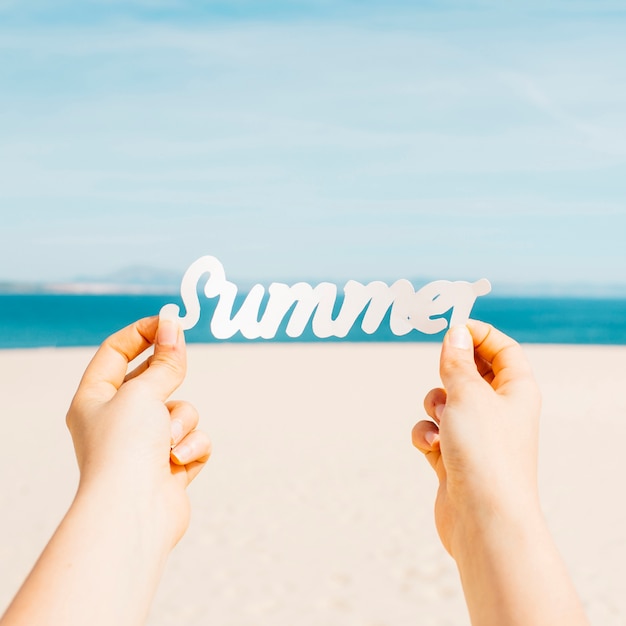 Free photo beach concept with hands holding summer letters