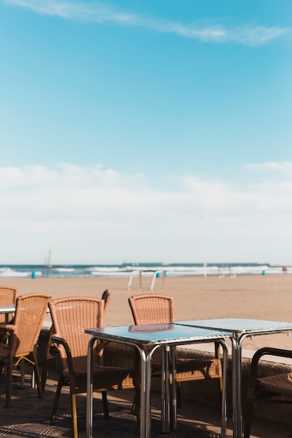 Foto gratuita concetto di spiaggia con tavoli e sedie