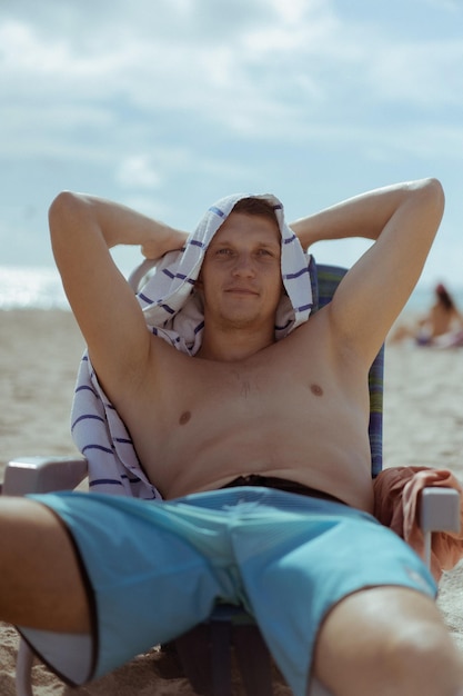 Beach Miami Florida USA, a young man resting on the beach in a sun lounger.