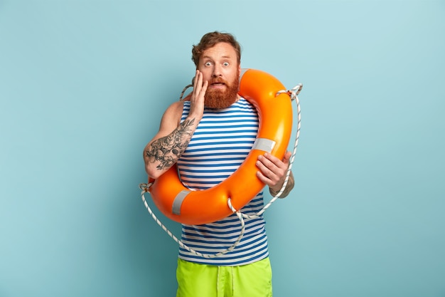 Beach safeguard male posing with lifebuoy