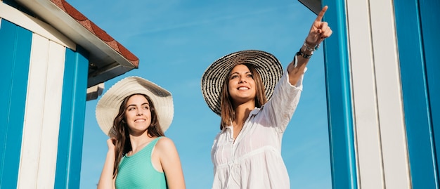 Foto gratuita concetto di spiaggia ed estate con due donna guardando da qualche parte