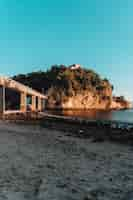 Free photo beach surrounded by the sea and rocks covered in greenery with a bridge in brazil