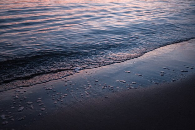日没時に日光の下で海に囲まれたビーチ
