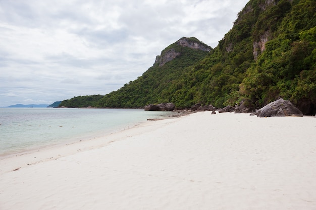 Пляж на тропическом острове. Чистая голубая вода, песок, облака.