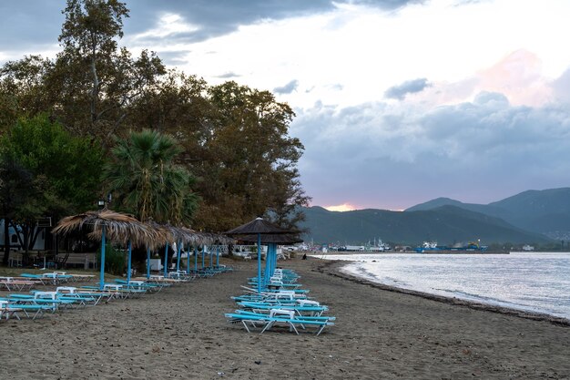 Beach with umbrellas and sunbeds on the coastline of Aegean sea, Greece