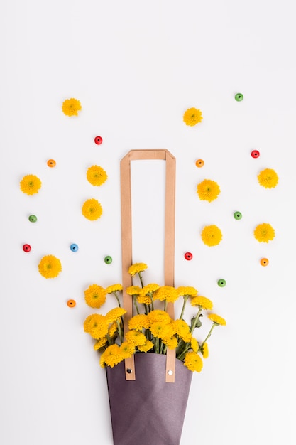 Beads and flowers near bag with bouquet