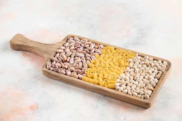Bean, pasta and chickpea on wooden tray.