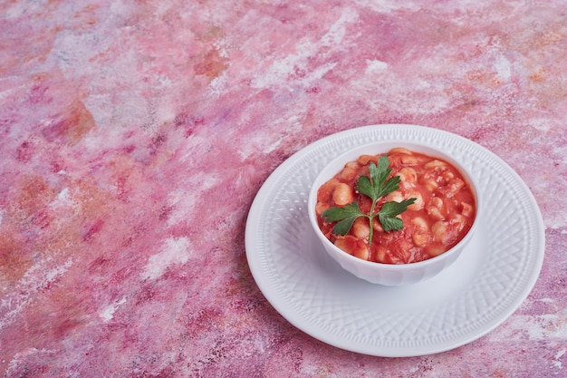 Zuppa di fagioli in salsa di pomodoro in un piatto bianco.