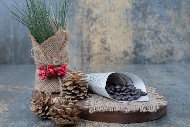 Beans in newspaper with pinecones on wooden board . High quality photo