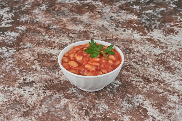 Foto gratuita zuppa di fagioli in salsa di pomodoro in una tazza di ceramica