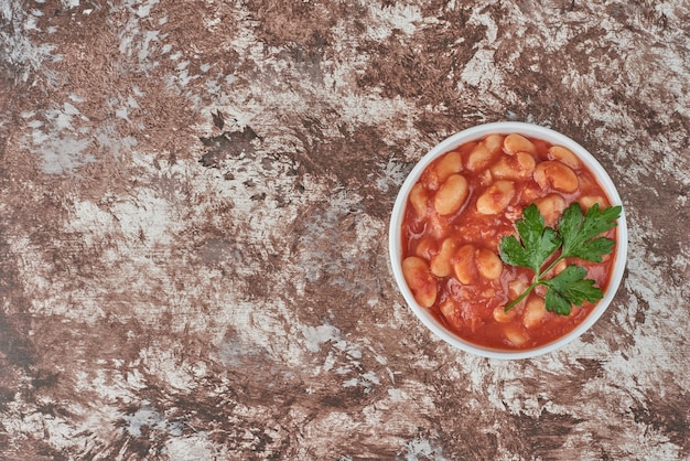 白いカップのトマトソースに豆のスープ