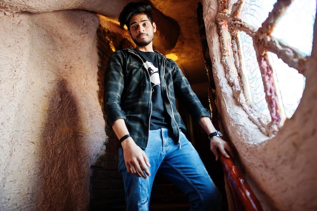 Beard asian man in casual wear stand inside house on stairs against window