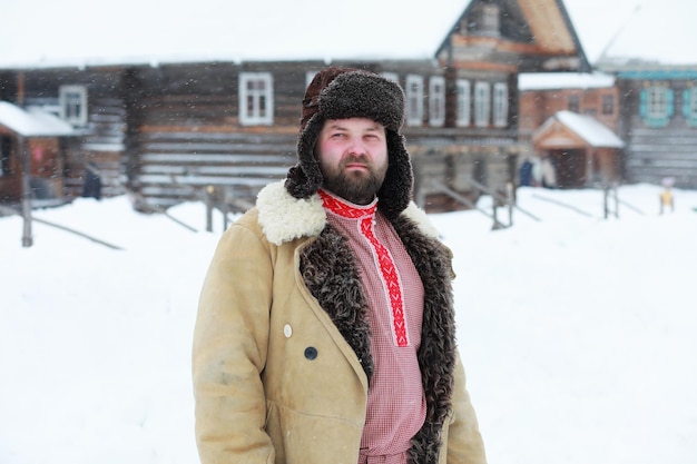 Бородатый мужчина в традиционном зимнем костюме крестьянского средневековья в россии