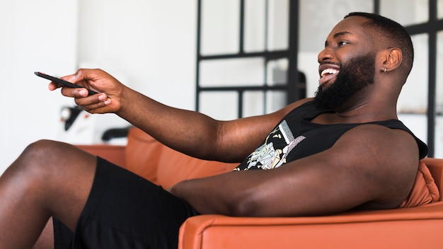 Bearded adult man watching tv at home