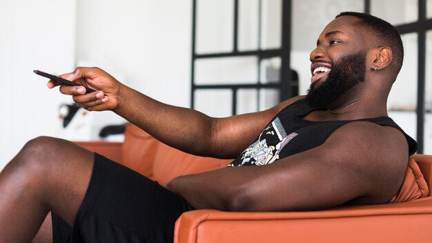 Bearded adult man watching tv at home