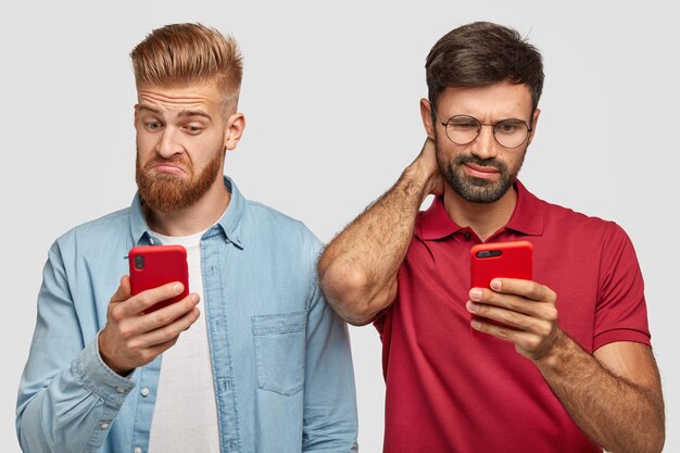 bearded brothers posing against the white wall