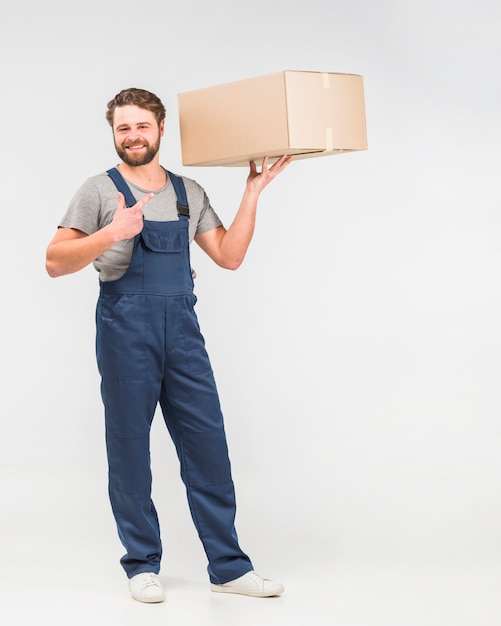Bearded delivery man pointing finger at box