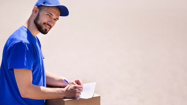 Bearded delivery man ready to hand out parcel